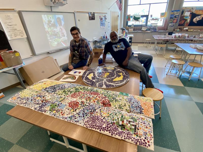 Love Creek Fireman Custodian Michael Thomas, right, displays the koi-themed mosaic he created that served as inspiration for mosaic panels made by students in art teacher Forest Allread’s classroom. Allread plans to have the panels permanently displayed in the school. ELLEN DRISCOLL PHOTO